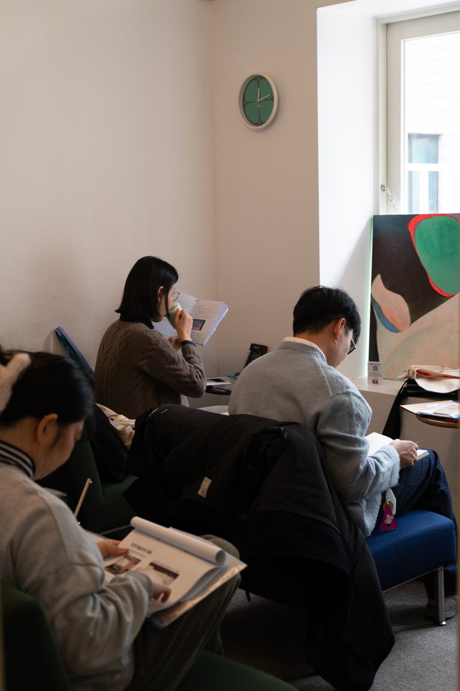 기록하는 방에서 각자 기록을 읽고 있는 관람객들